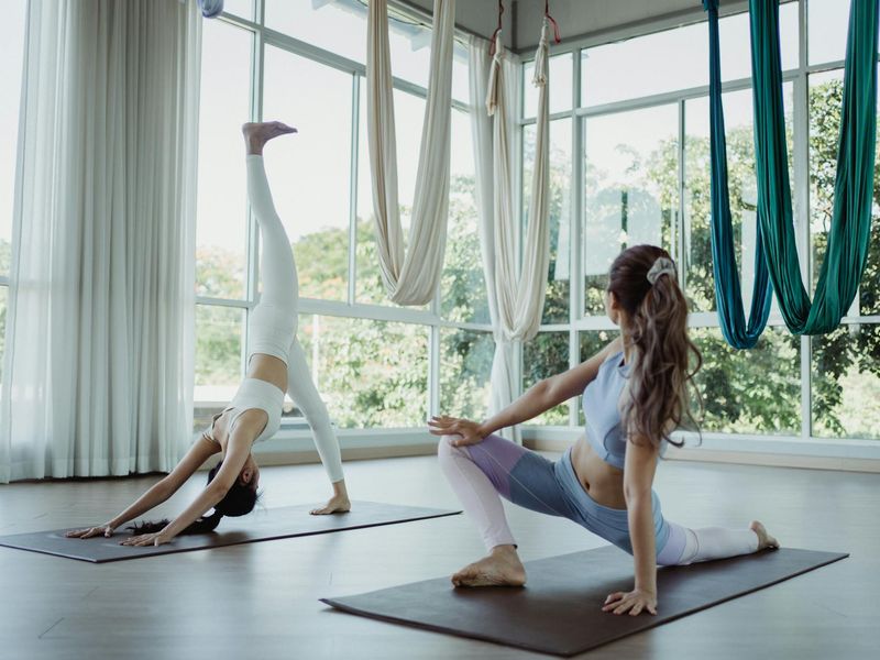 Wide view of a modern bright exercise studio with mats